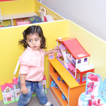 Child enjoying pretend house and role-play activities at Wooray Patna.